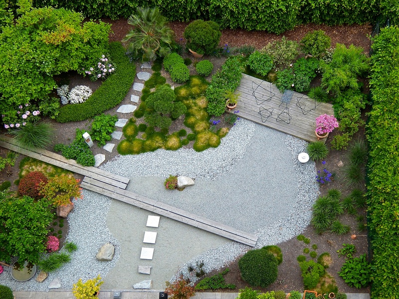 Aerial short of a backyard with pebles, plants and stone pathways.