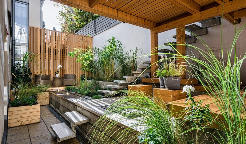 backyard with wooden deck, tall grasses and concrete steps