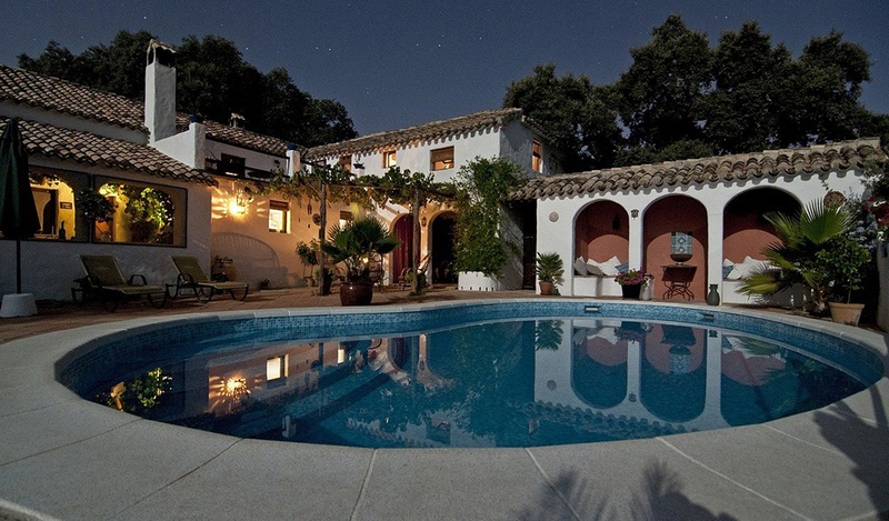 Nighttime shot of a traditional house with a small pool.